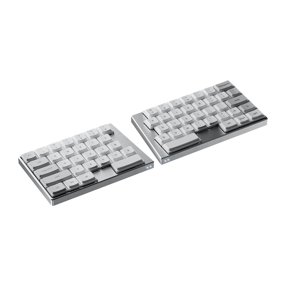 Angled studio shot of the silver ElimKeys Elytra split mechanical keyboard, featuring white low-profile keycaps with printed legends, separated on a pure white background.