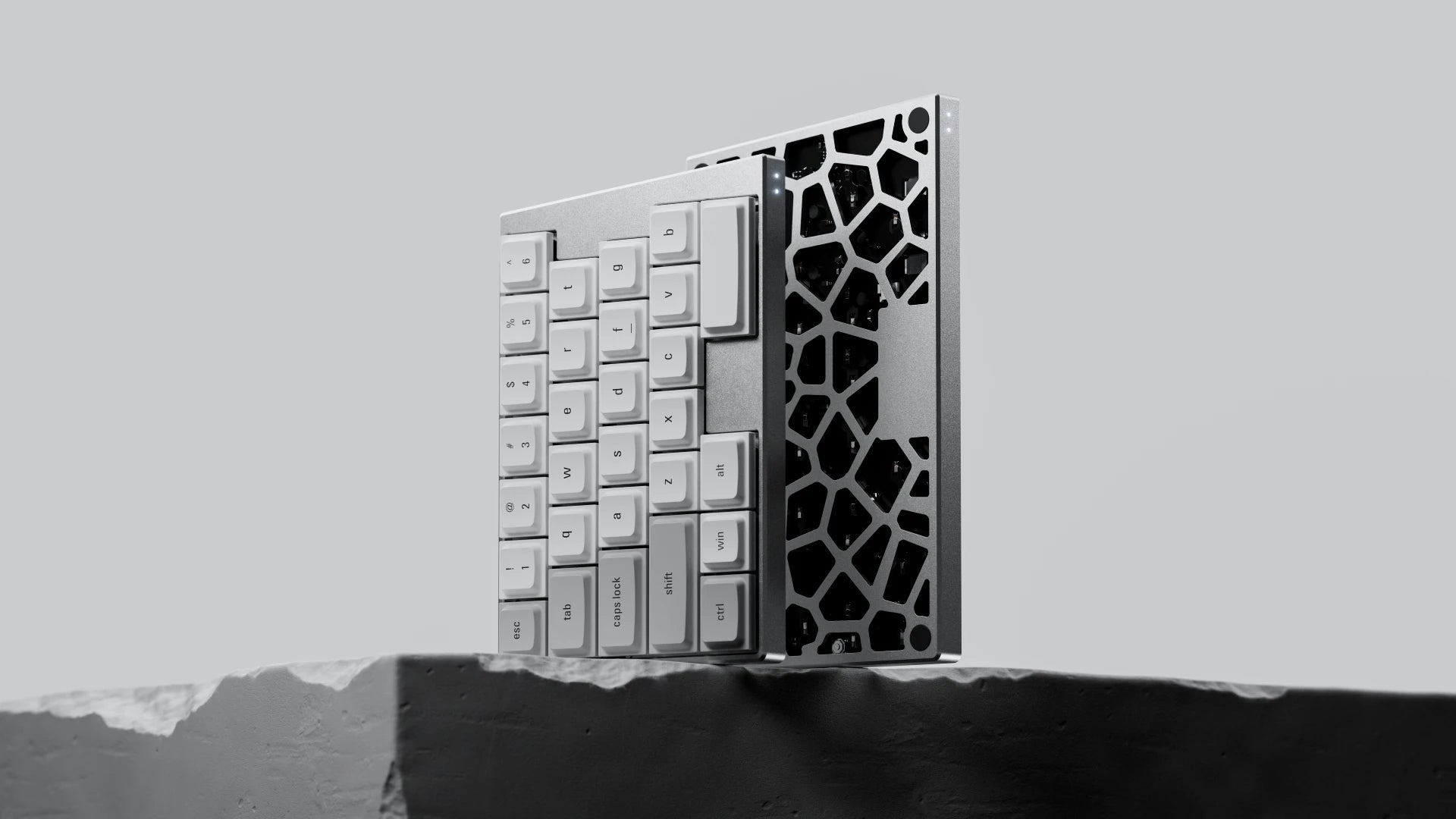 A person typing on the silver ElimKeys Elytra mechanical keyboard with both halves joined together in a compact layout, demonstrating its versatility on a wooden desk.